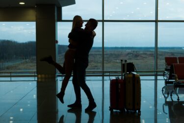 空港で抱き合うカップルの画像